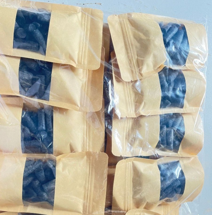 Navy blue firelighter pellets in kraft paper retail bags with a clear window
